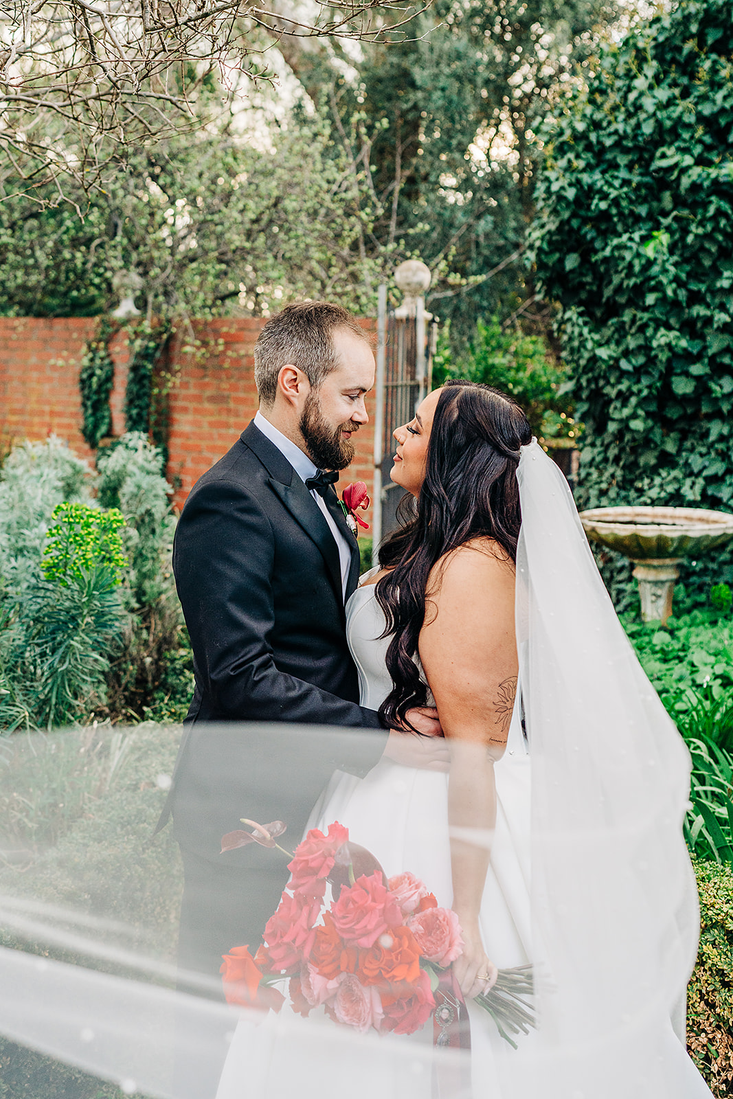 couple touching noses with veil sweeping towards camera