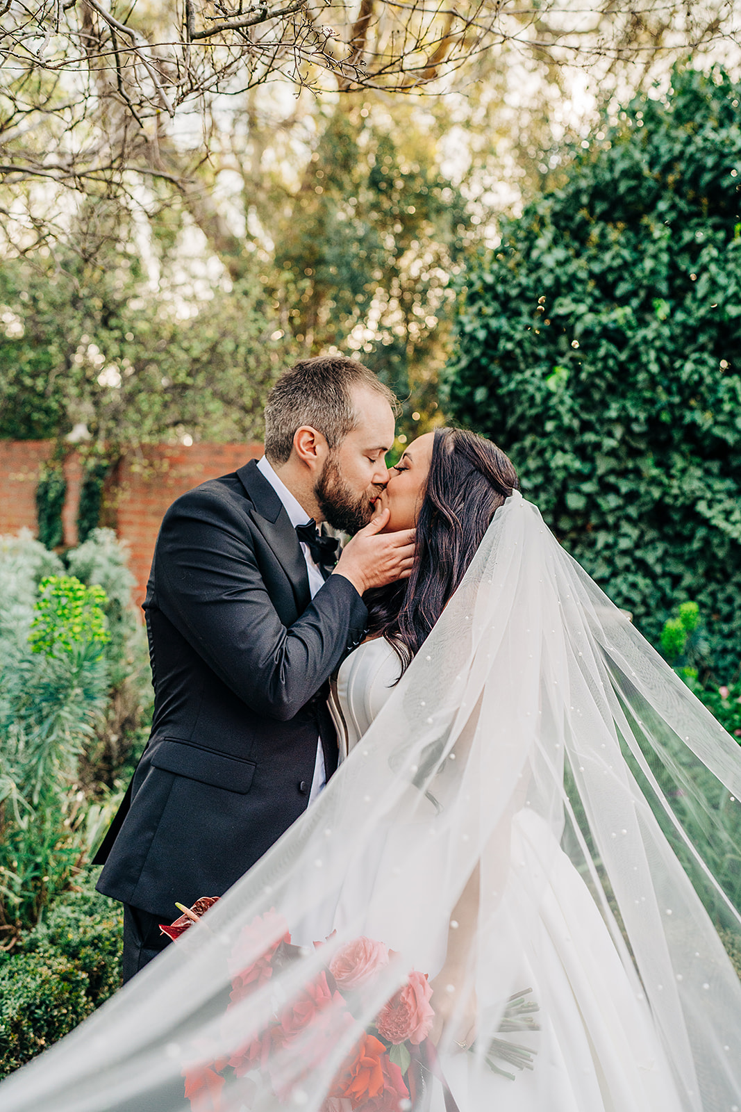 couple kissing with veil swooping towards camera at harvest home