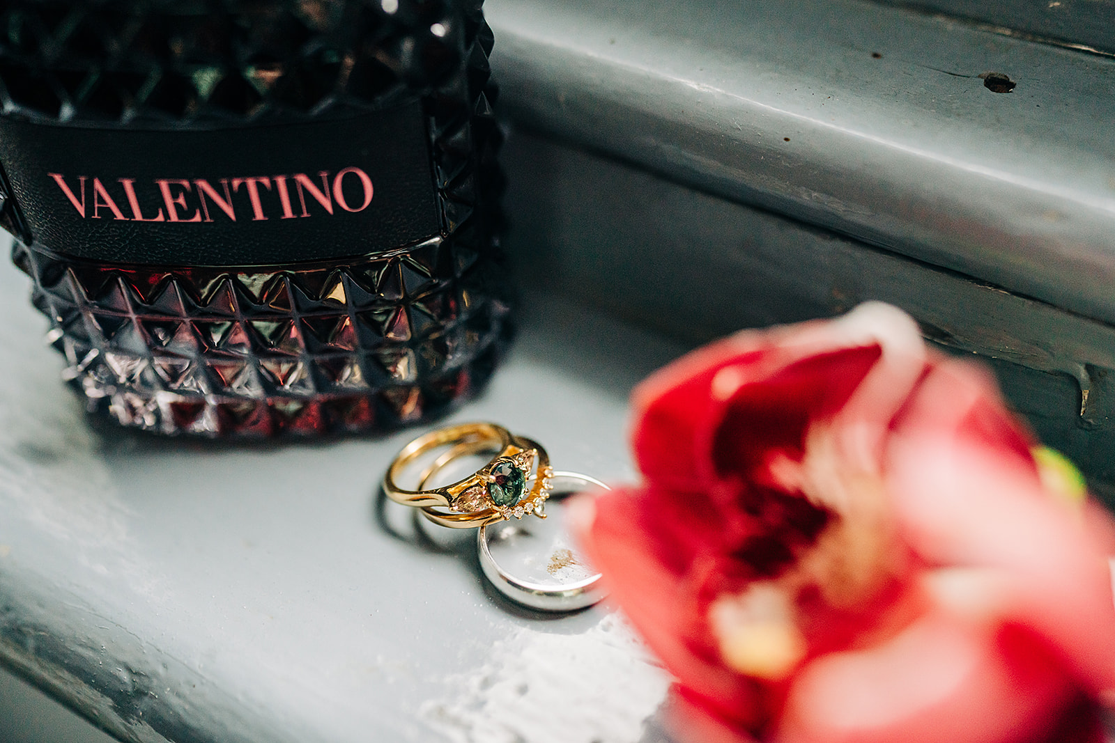 detail photos of the couples rings, grooms lapel flower and grooms cologne