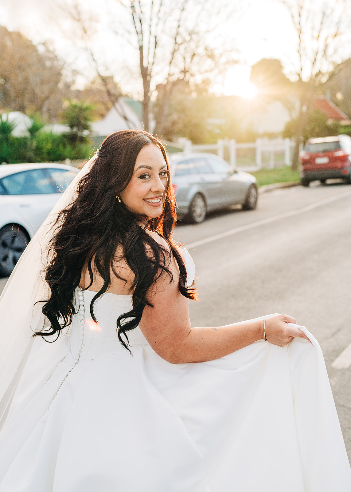 bride hayley peering over shoulder while running down street in avenel