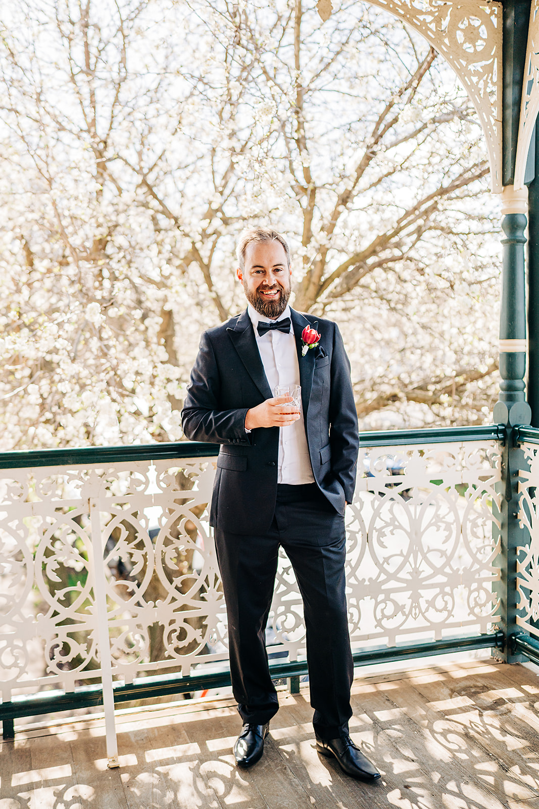 portrait of groom holding a scotch glass on balcony of harvest home