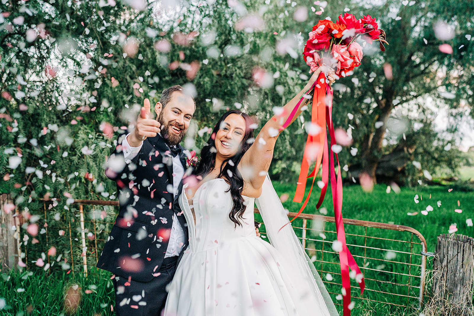 couple cheering and giving finger guns surrounded by falling confetti