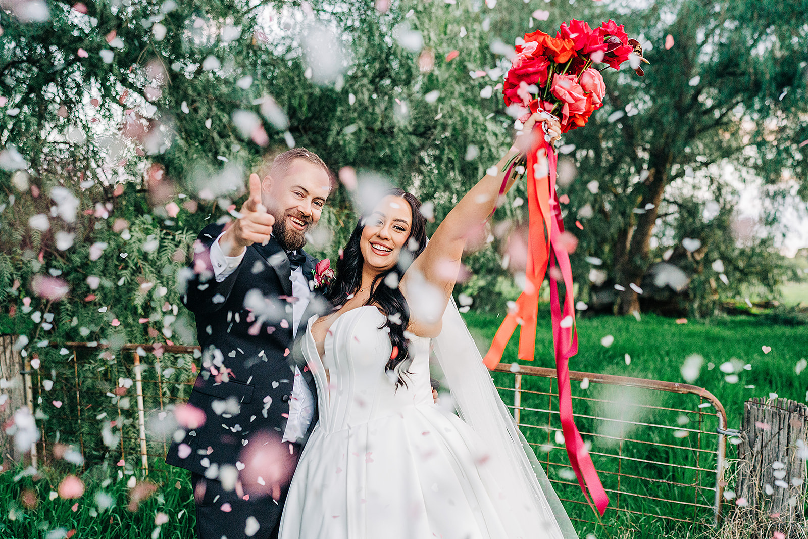 couple cheering and giving finger guns surrounded by confetti