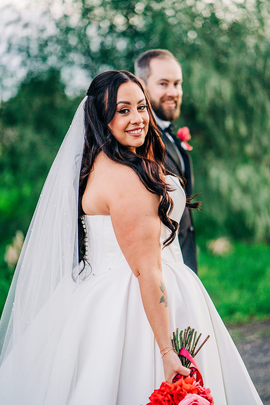 bride peering over shoulder while walking